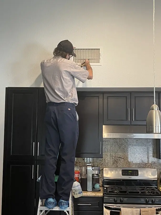 Technician inspecting an air vent during HVAC service in Lakeside